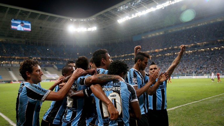 Gremistas comemoram o gol de Werley, o segundo da noite (AFP PHOTO/Jefferson BERNARDES)
