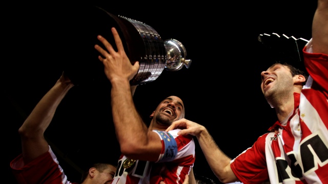 Argentina's Estudiantes de la Plata's Juan Sebastian Veron, center, holds up the trophy while celebrating after winning the Copa Libertadores championship in Belo Horizonte, Brazil, Wednesday, July 15, 2009. Argentina's Estudiantes de la Plata defeated Brazil's Cruzeiro won 2-1. (AP Photo/Natacha Pisarenko)