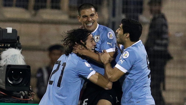 Maxi Pereira celebra com Cavani e Su&aacute;rez o primeiro gol uruguaio (AP Photo/Hassan Ammar)