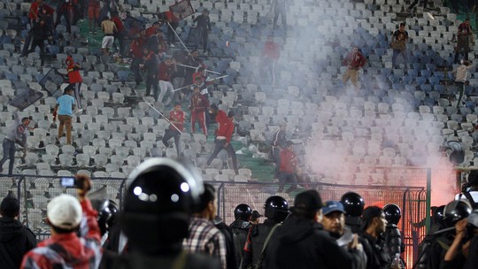 Fans of Egypt's Al-Ahly flee after riot police fired tear gas during clashes after their African Super Cup soccer match against Tunisia's CS Sfaxien at Cairo Stadium