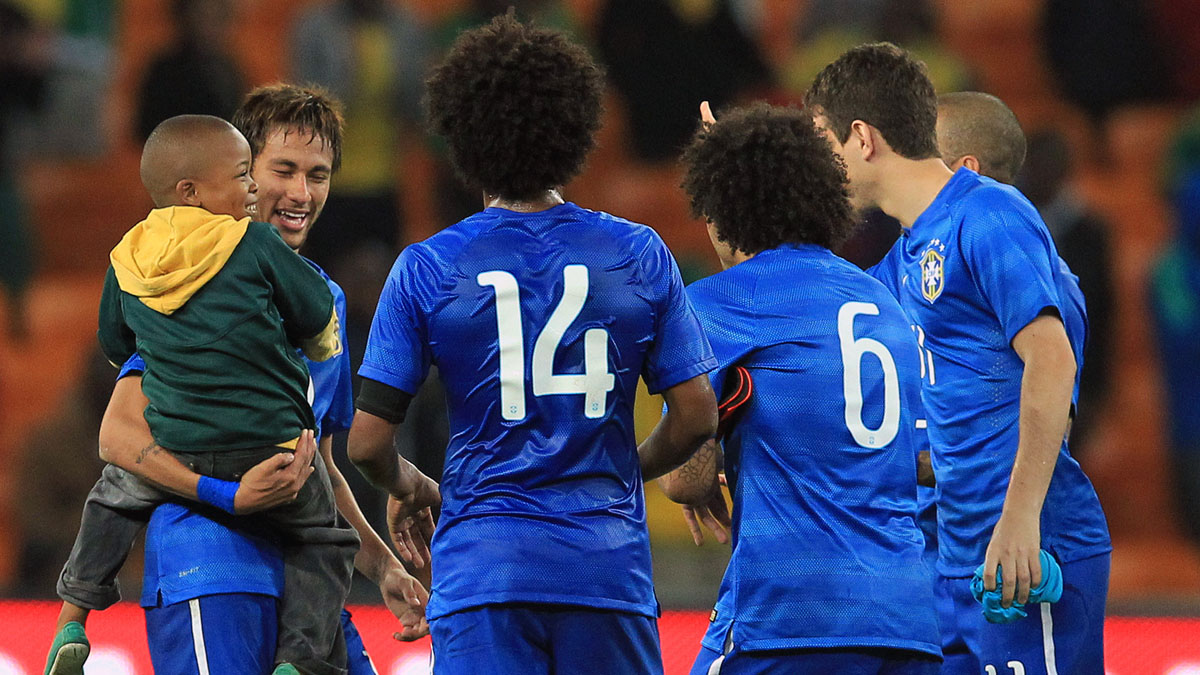 Neymar com o garoto sul-africano entre jogadores da sele&ccedil;&atilde;o brasileira (AP Photo/Themba Hadebe)