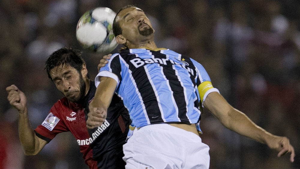 Barcos, do Gr&ecirc;mio, e Villalba disputam uma bola pelo alto no empate entre Newell's Old Boys e Gr&ecirc;mio (AP Photo/Eduardo Di Baia)