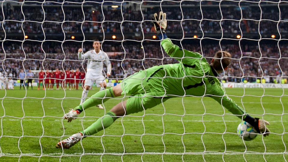Bayern Munich goalkeeper Manuel Neuer saves a penalty kick by Cristiano Ronaldo on his way to winning a semi final second leg Champions League soccer match against Real Madrid's at the Santiago Bernabeu stadium, in Madrid, Wednesday, April 25, 2012. (AP Photo/Daniel Ochoa de Olza)