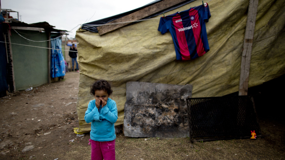 Ocupa&ccedil;&atilde;o no sub&uacute;rbio de Buenos Aires tem Daisy Gomes, a crian&ccedil;a da foto, e uma camisa do San Lorenzo pendurada. A f&eacute; &eacute; pela esperan&ccedil;a de conseguir habita&ccedil;&atilde;o - e para o San Lorenzo seguir adiante (AP Photo/Natacha Pisarenko)