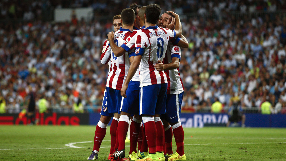 Arda Turan, do Atl&eacute;tico de Madrid, &eacute; abra&ccedil;ado por companheiros (AP Photo/Gabriel Pecot)