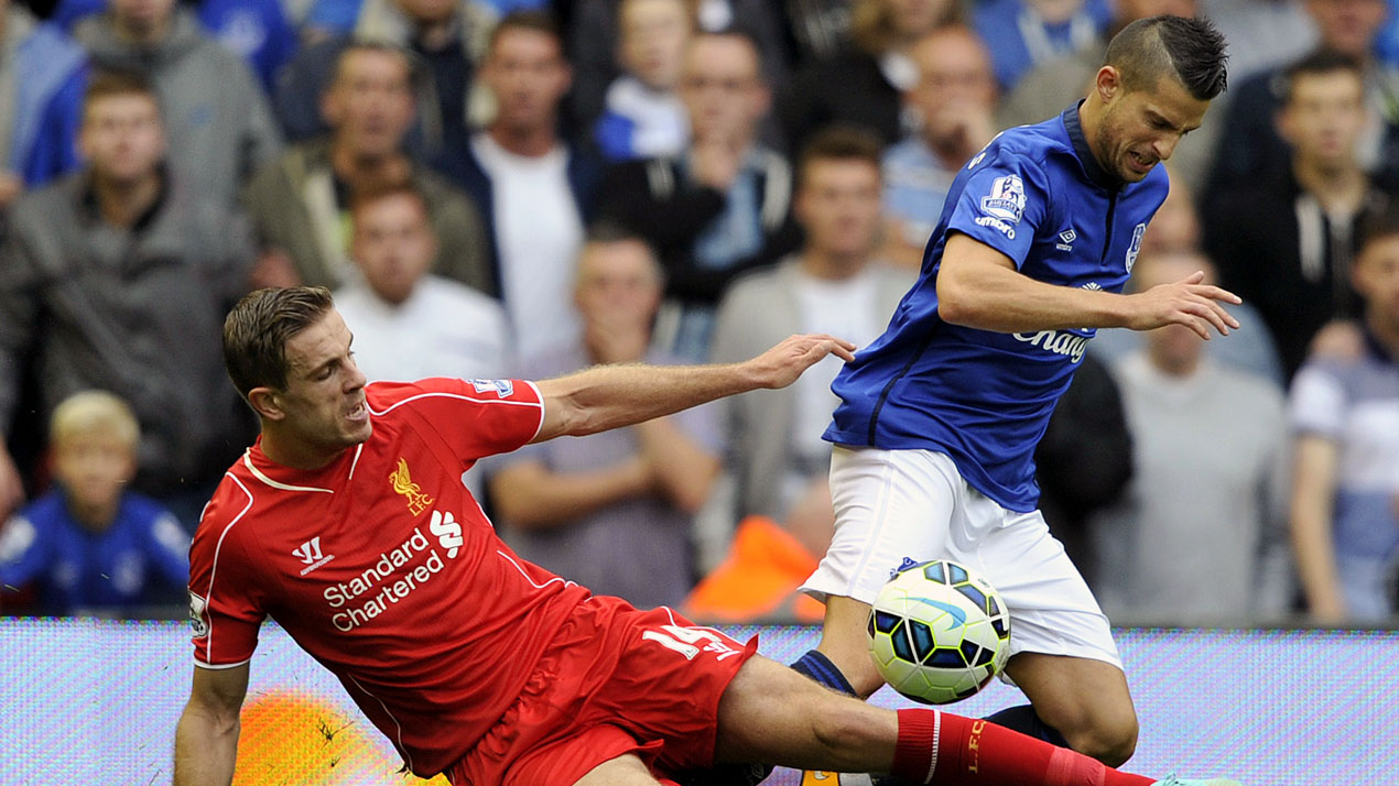 Henderson, do Liverpool, t&aacute; um carrinho em Mirallas, do Everton (AP Photo/Clint Hughes)