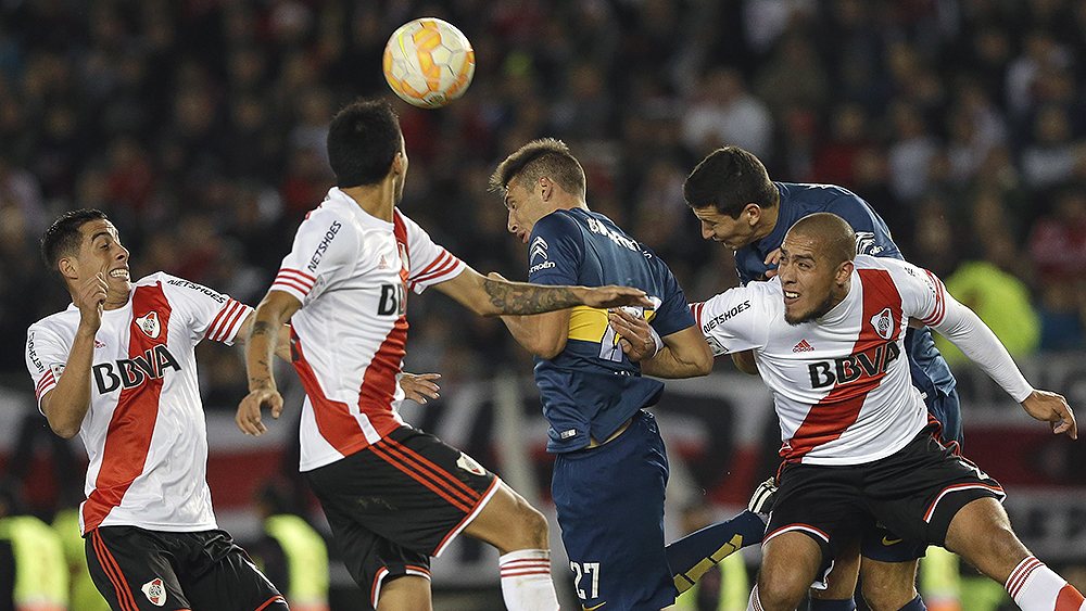 Jogadores de River Plate e Boca Juniors disputam bola pelo alto (AP Photo/Victor R. Caivano)