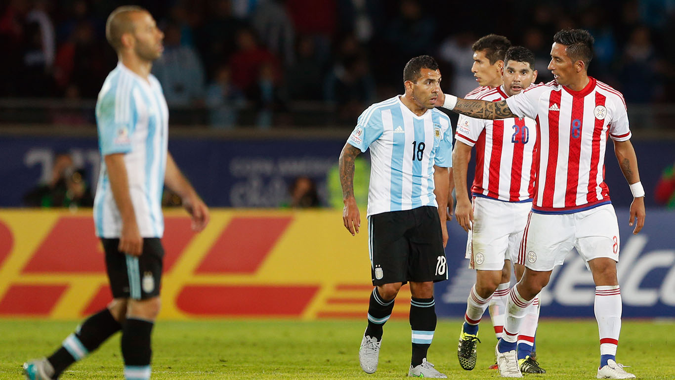 Tevez (esq.) &eacute; cumprimentado por Barrios, do Paraguai (AP Photo/Andre Penner) 