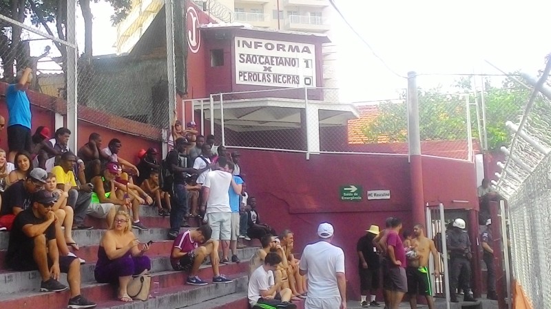 Haitianos se abrigam na sombra atr&aacute;s de um dos gols