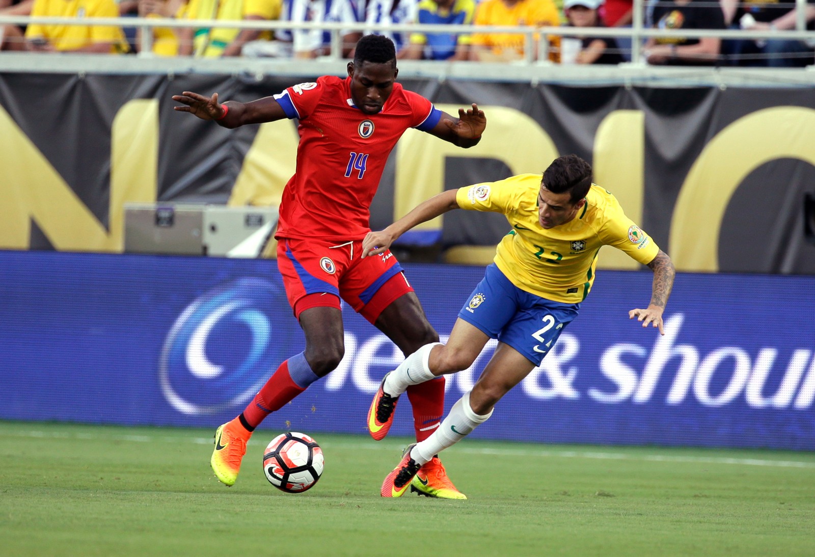 Haiti's James Marcelin (14) and Brazil's Philippe Coutinho (22) collide while going for the ball during the first half of a Copa America group B soccer match at Camping World Stadium, Wednesday, June 8, 2016, in Orlando, Fla. (AP Photo/John Raoux)