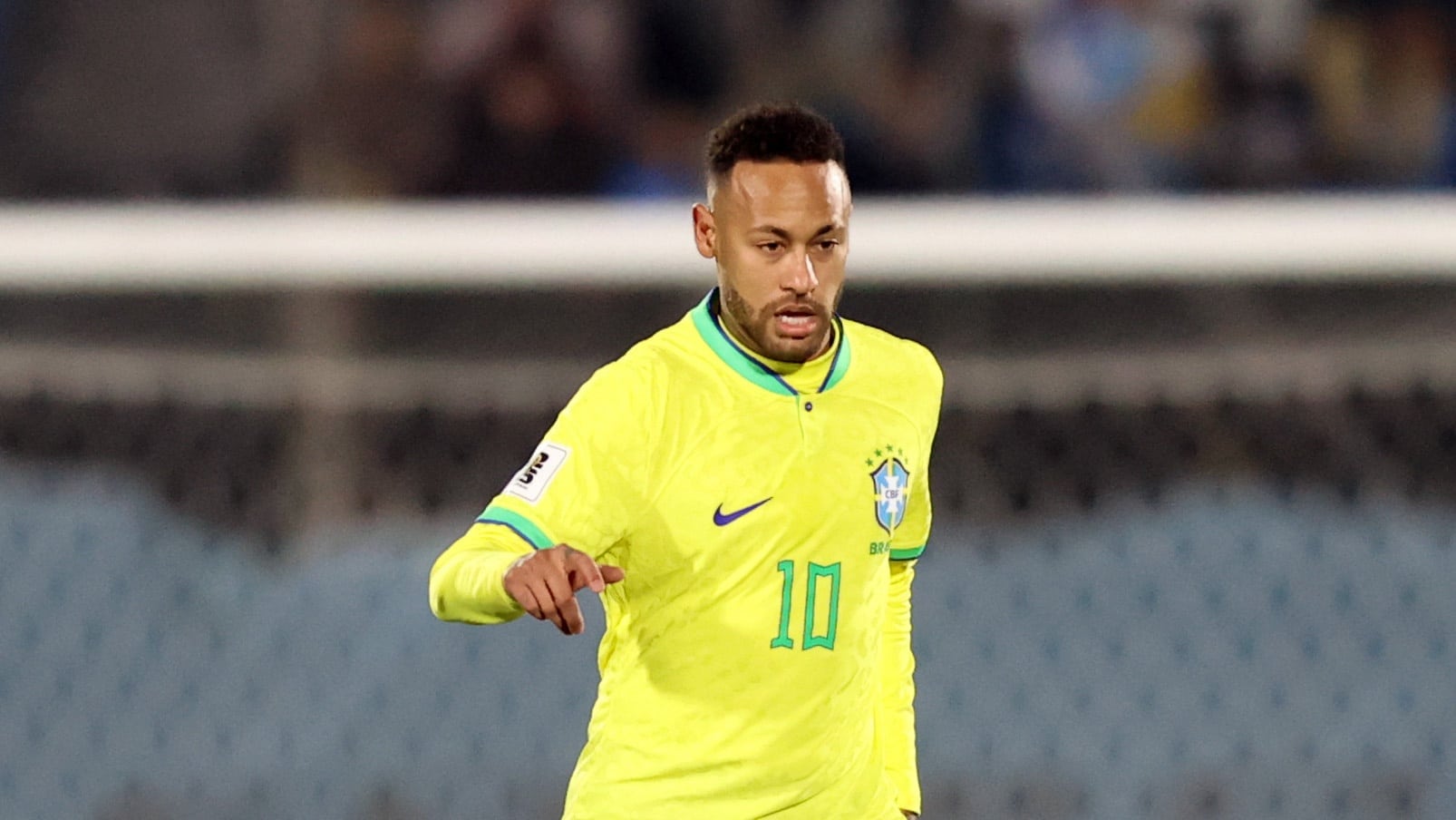 Neymar vestindo a camisa amarela da Sele&ccedil;&atilde;o Brasileira observa movimenta&ccedil;&atilde;o de jogadores