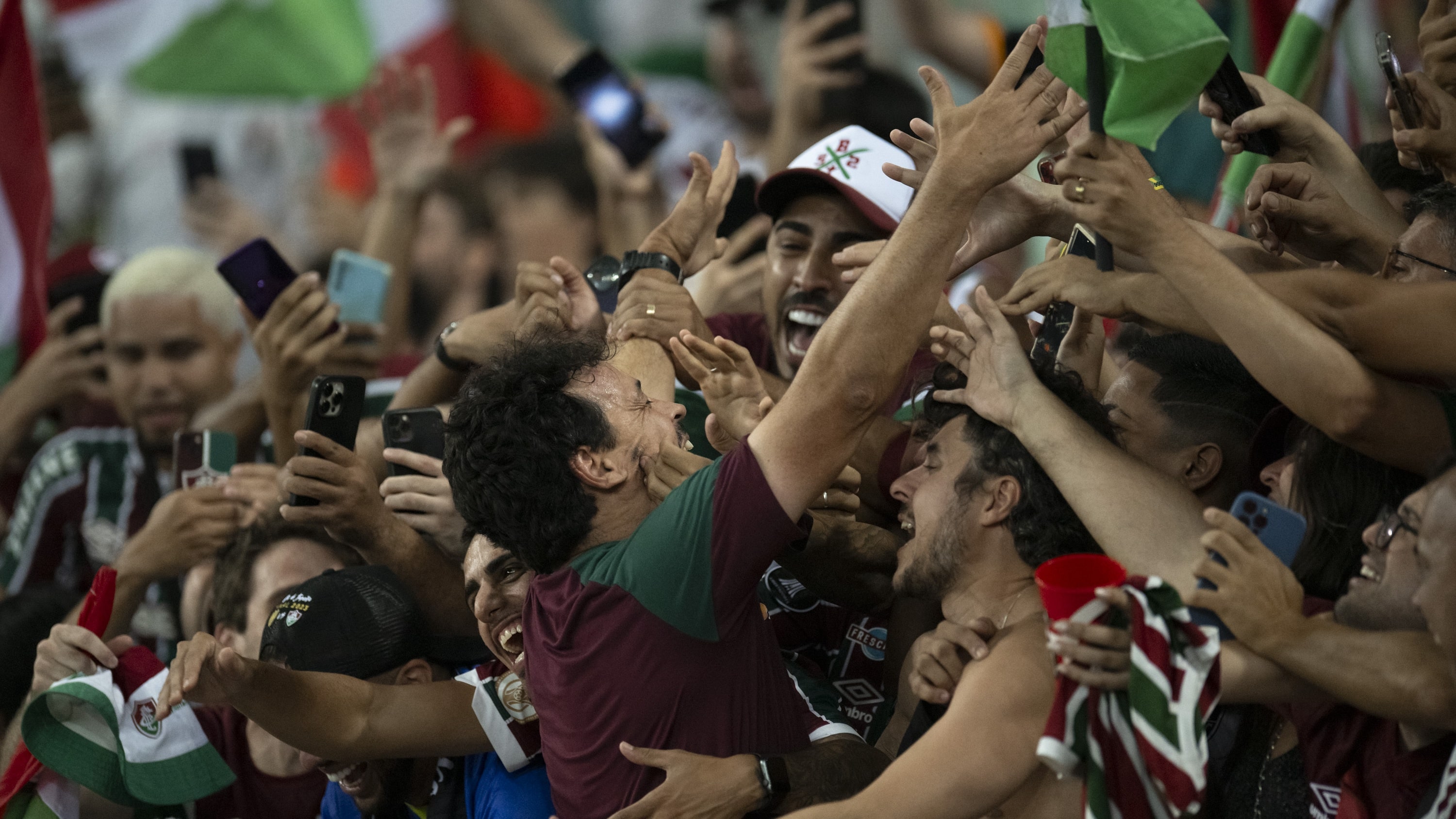 Fernando Diniz nos bra&ccedil;os da torcida ap&oacute;s o Fluminense conquistar o t&iacute;tulo da Libertadores (Foto: Icon Sport)
