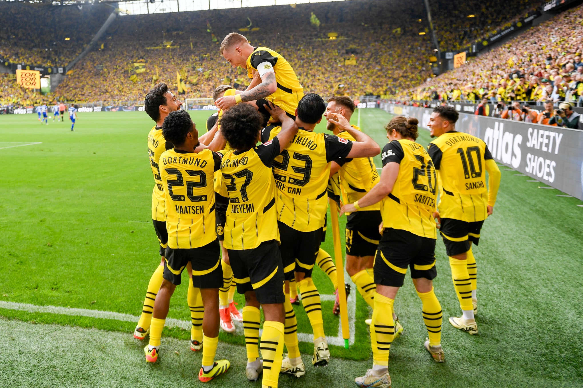 Marco Reus, emocionado, &eacute; levantado pelos companheiros ap&oacute;s o gol que marcou na goleada do Borussia Dortmund - Foto: Icon sport