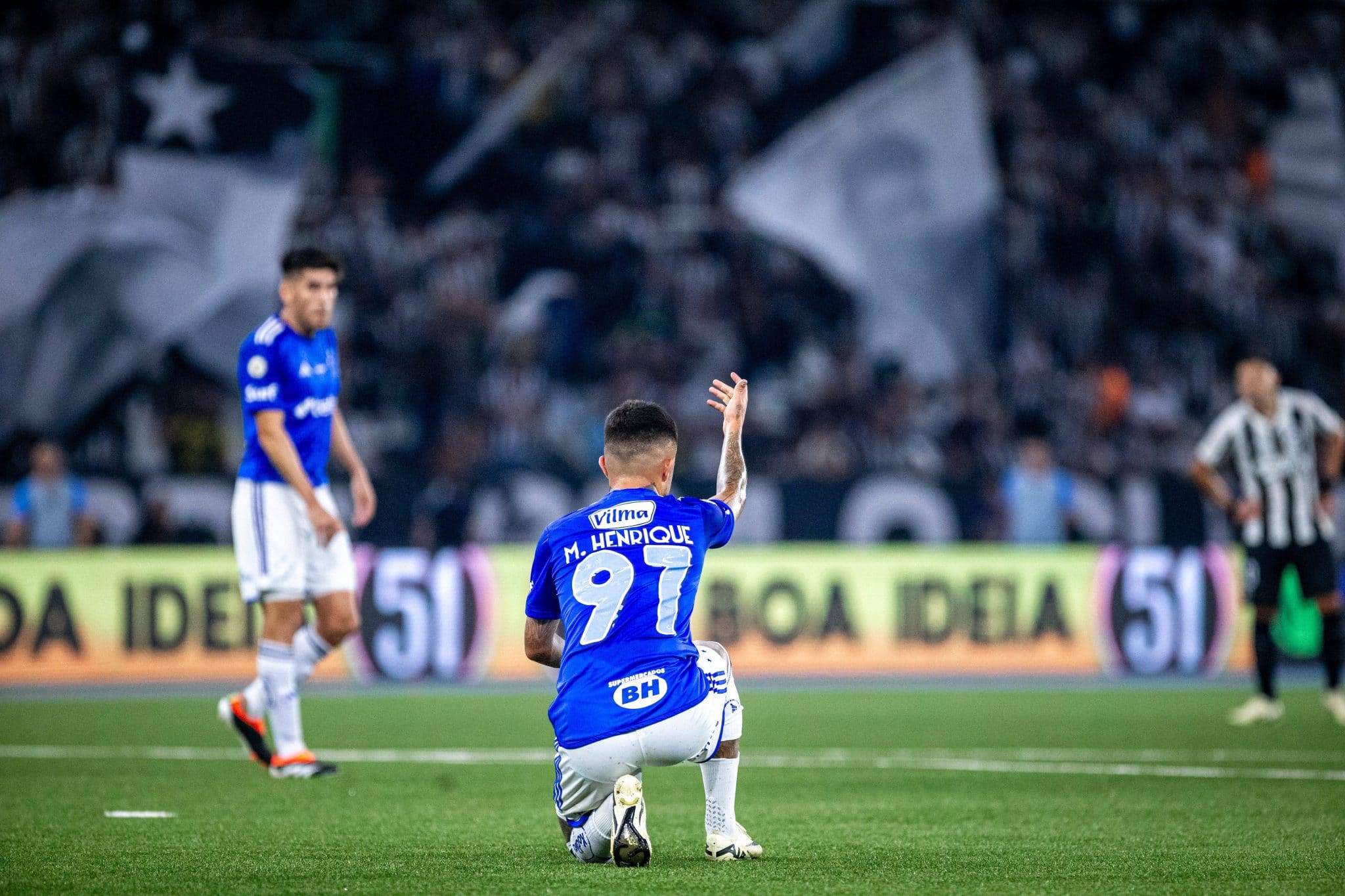 Matheus Henrique ajoelhado no gramado durante a partida entre Cruzeiro e Botafogo