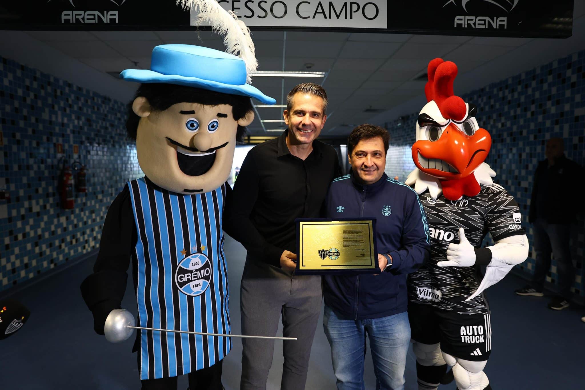 Victor recebe placa de Alberto Guerra com a presen&ccedil;a dos mascotes de Gr&ecirc;mio e Atl&eacute;tico-MG.