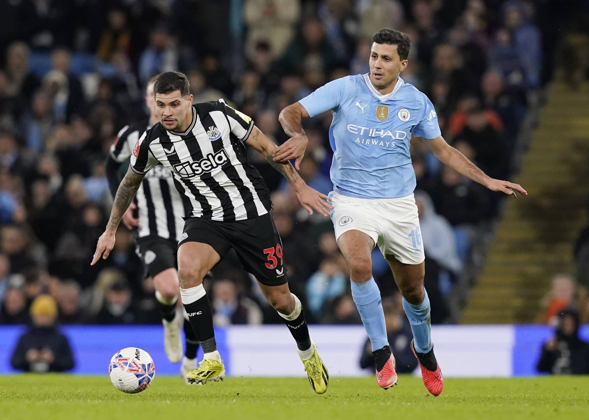 Manchester, England, 16th March 2024. Bruno Guimaraes of Newcastle United tussles with Rodri of Manchester City during T