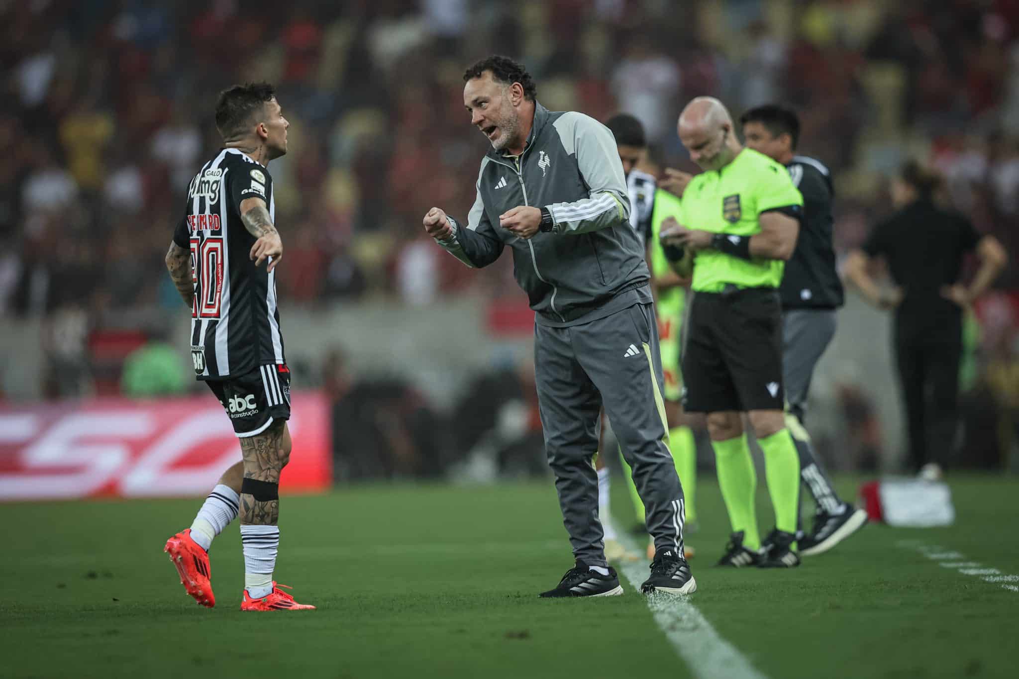 Bernard conversa com Milito na beira do campo 