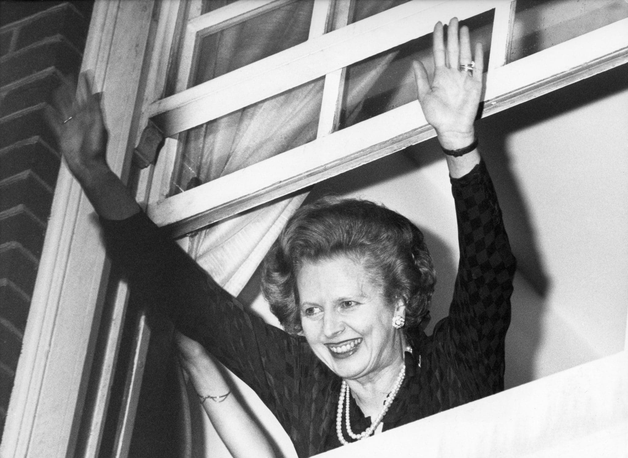The window of success frames the jubilant Premier Margaret Thatcher waving to well wishers shortly a