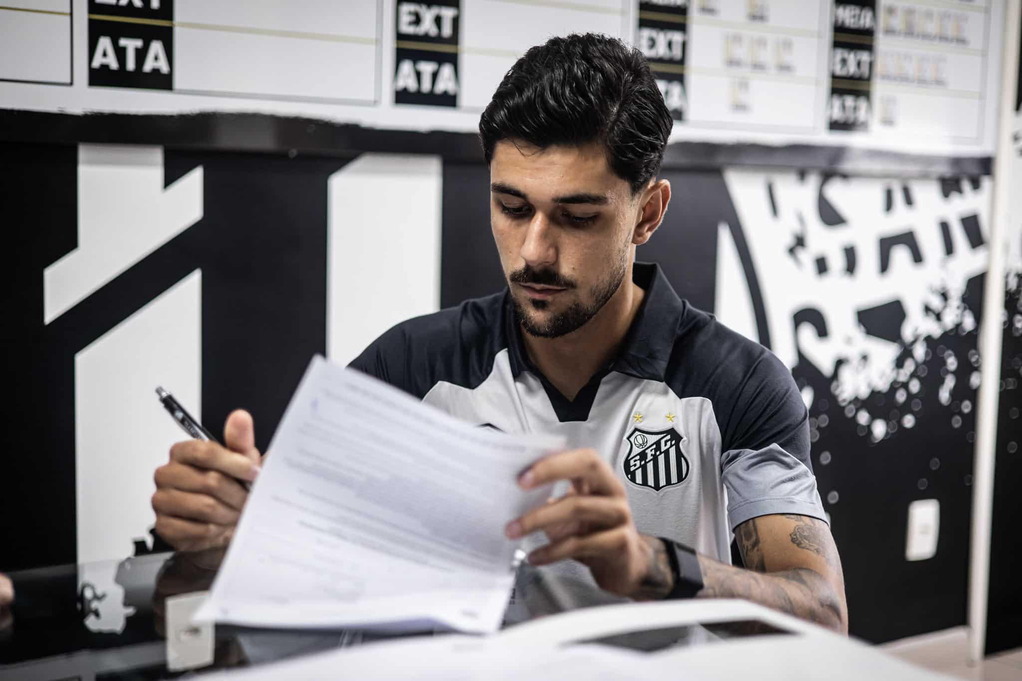 Jo&atilde;o Basso assinando contrato com o Santos