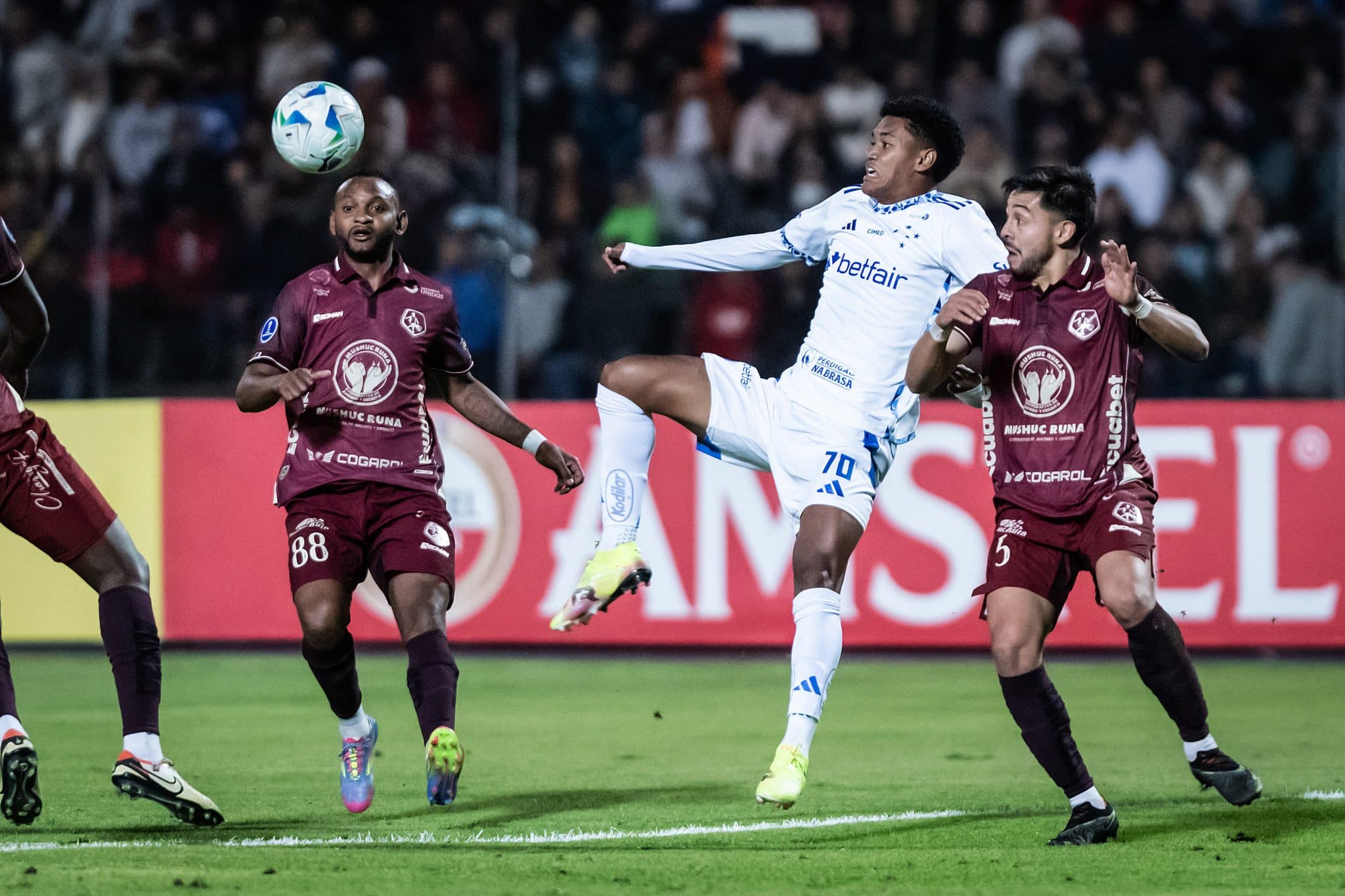 Kaique Kenji, do Cruzeiro, disputa bola com marcadores do Mushuc Runa (Foto: Gustavo Aleixo/Cruzeiro)