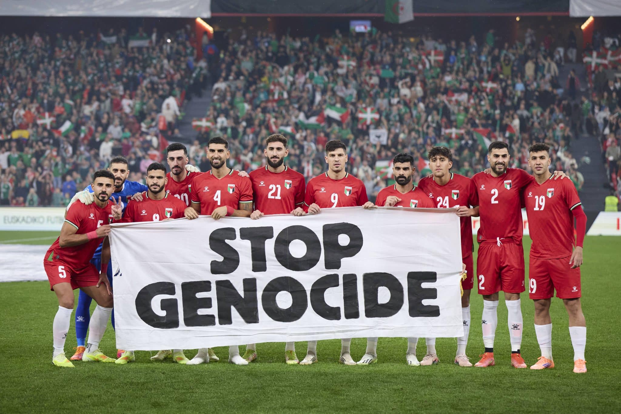 Jogadores da Palestina seguram faixa com os dizeres 'pare o genoc&iacute;dio' antes de amistoso com Pais Basco