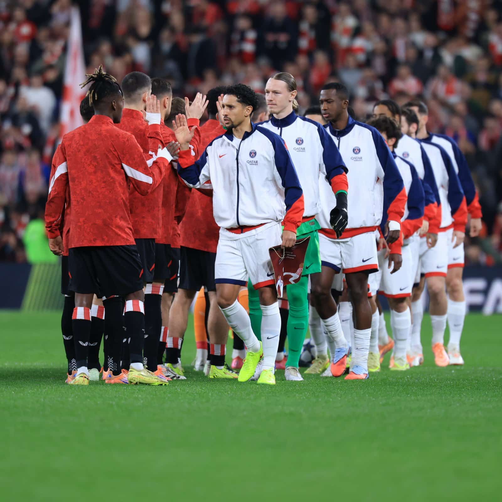 Jogadores de Athletic Bilbao e PSG se cumprimentam antes de jogo pela Champions League